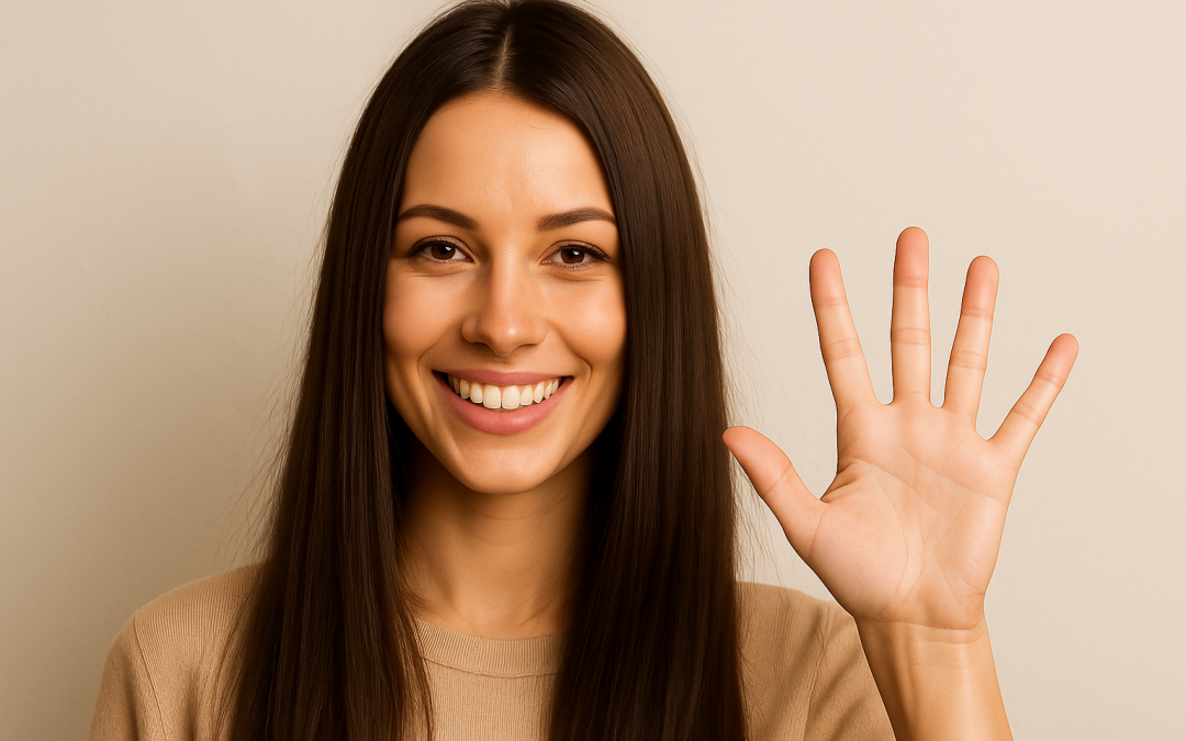 Femme souriante aux cheveux longs et bruns, portant un chandail beige, faisant un signe de salut avec la main levée devant un fond uni clair